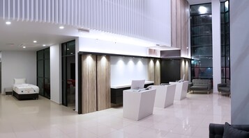 Un área de recepción moderna con mostrador, asientos y una cama con colchón etiquetado "Royal Platinum".