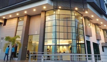 Un edificio moderno con fachada de vidrio, una escalera y una barandilla en primer plano.