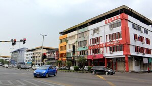 A multi-story building with various businesses including a hotel and a restaurant. - Super OYO 1173 Mandyrin Hotel (Sibu)