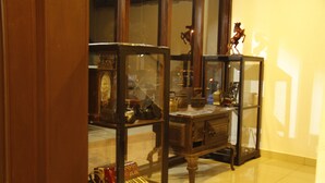 Une pièce comprenant un meuble en bois contenant divers objets, notamment une horloge et une petite statue.