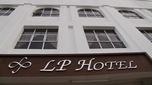 L’extérieur de l’hôtel LP se distingue par une enseigne bien visible et de nombreuses fenêtres.