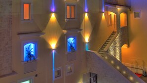 Un hotel con un letrero destacado que dice 'HOTEL' y la marca 'CENACOLO'. Cuenta con varias ventanas y una escalera que conduce a los pisos superiores.