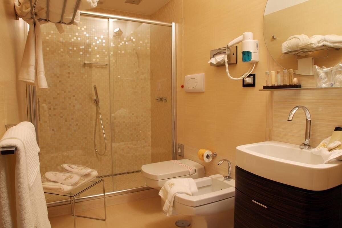 Un baño moderno con cabina de ducha de vidrio, lavabo y tocador.
