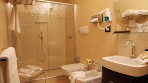 Un baño moderno con cabina de ducha de vidrio, lavabo y tocador.