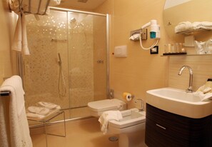 A modern bathroom with a glass shower enclosure, a sink, and a vanity.