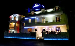 Un hotel de varios pisos con un letrero llamativo que dice "Cenao Hotel".