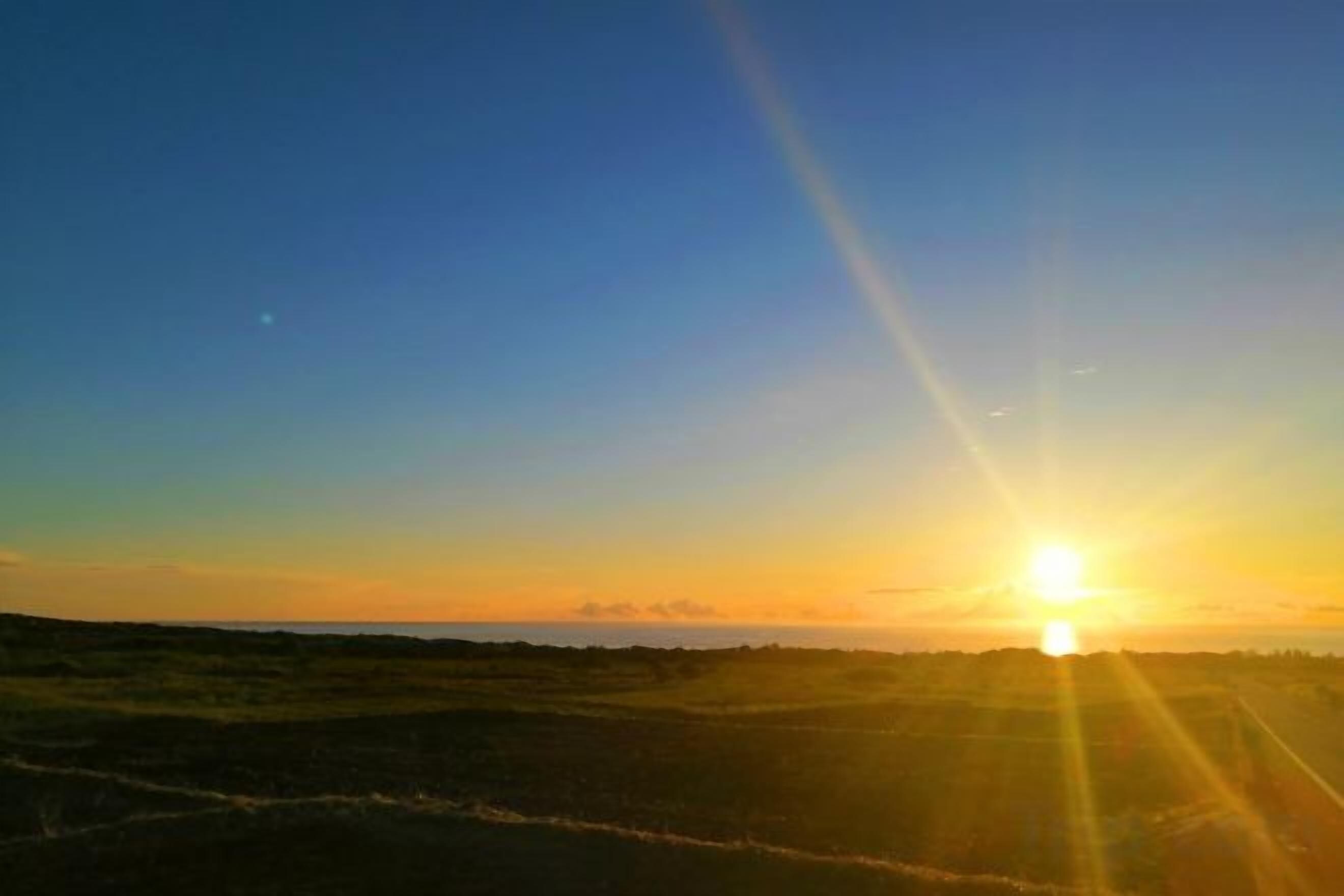A sunset over a flat landscape with a clear horizon.