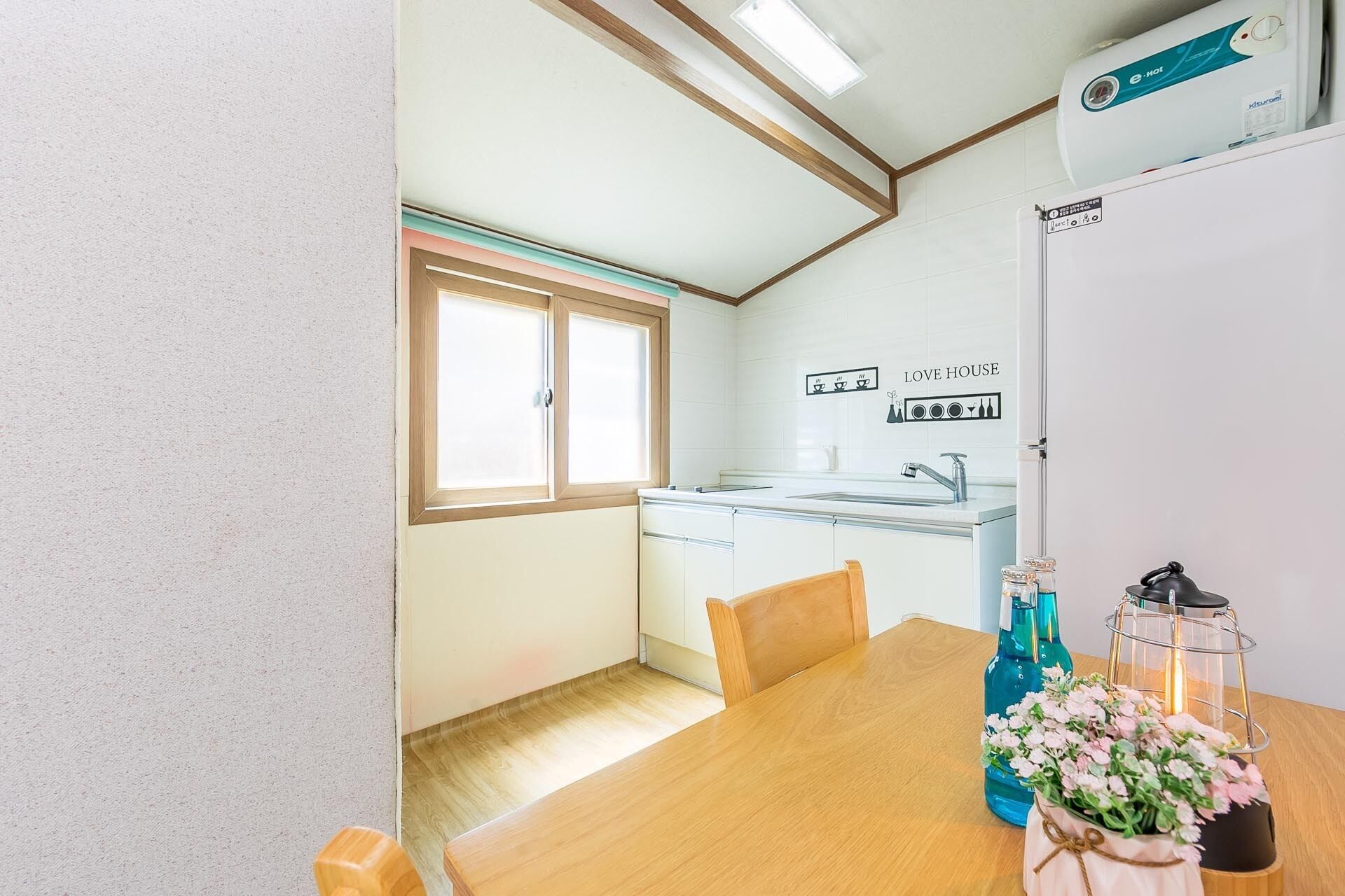 A compact kitchen with a window, a sink, and a dining table with chairs.