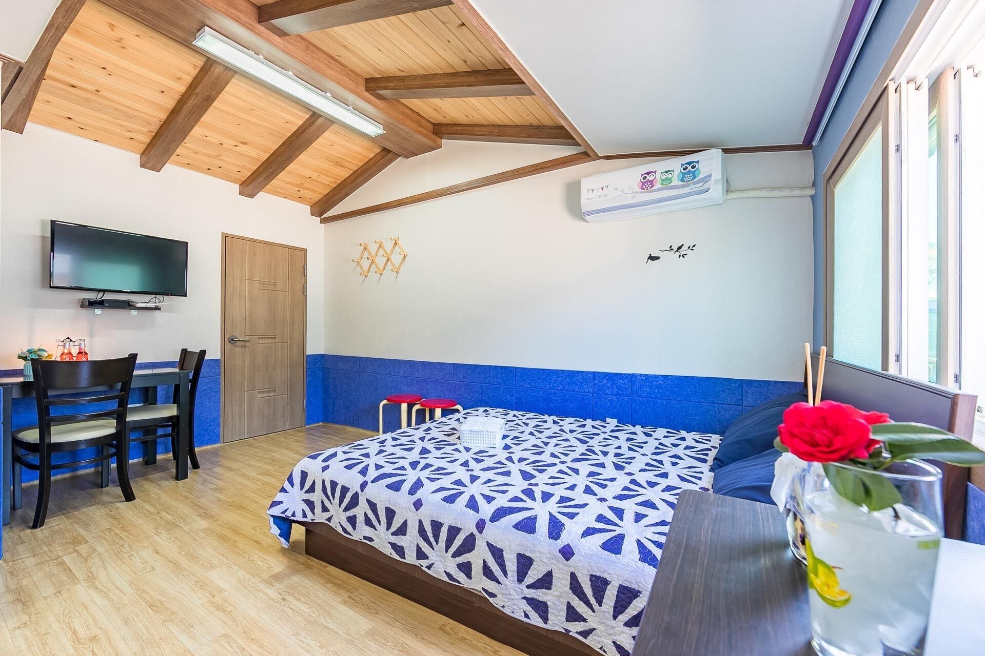 A room with a bed, a desk, a TV, and a window.