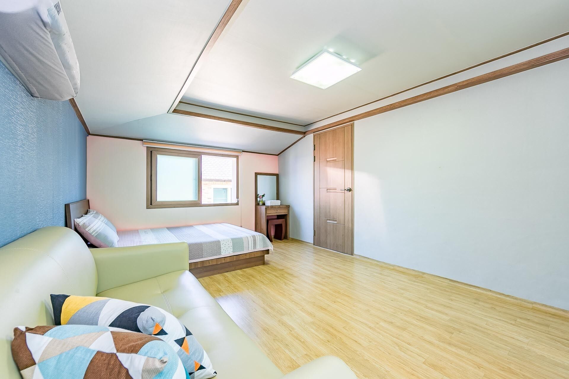 Un dormitorio con cama, escritorio, armario y ventana.