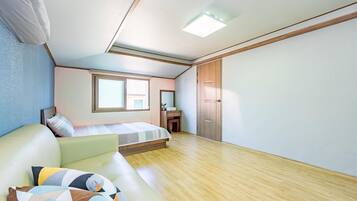 Un dormitorio con cama, escritorio, armario y ventana.