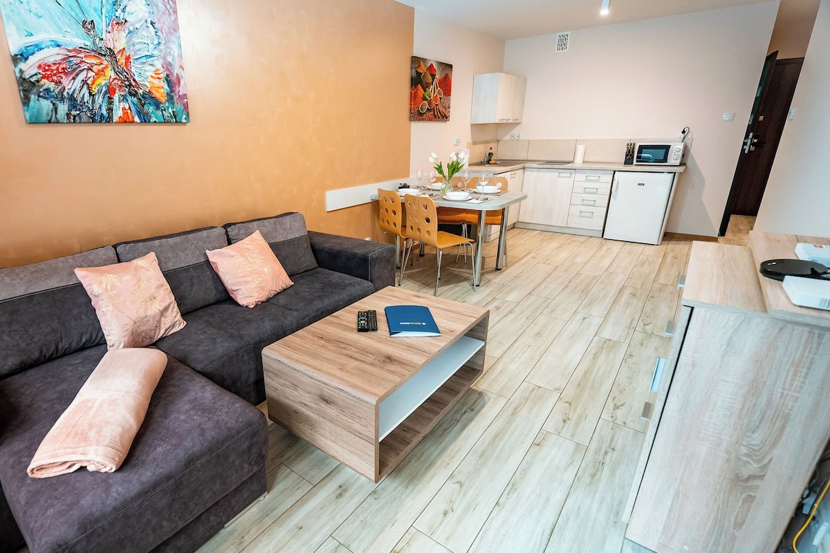 Un salon moderne avec un canapé, une table basse et un coin repas avec des chaises.