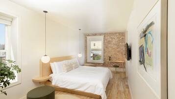 Un dormitorio moderno con una cama de madera, una pared de ladrillo y un ventanal grande.