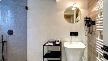 A modern bathroom with a glass-enclosed shower, a white sink, and a mirror with integrated lighting.