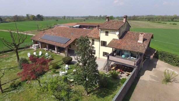 A two-story house with a large garden, solar panels, and a dining area. - Agriturismo La Morosina (Abbiategrasso)