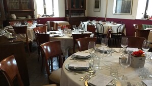 A restaurant with multiple tables set for dining, each with plates, cutlery, and glasses. - Agriturismo La Morosina (Abbiategrasso)