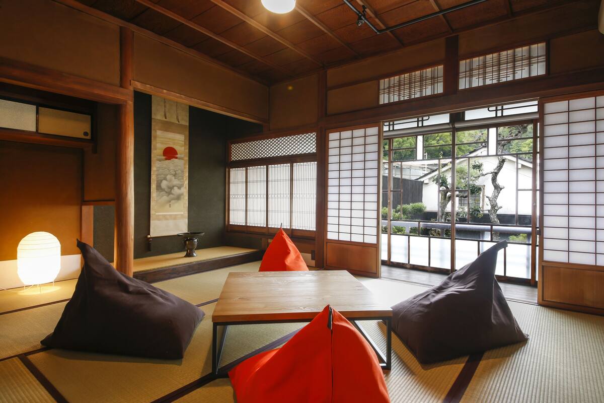 Een traditionele Japanse kamer met tatami matten, een lage houten tafel en kussens.
