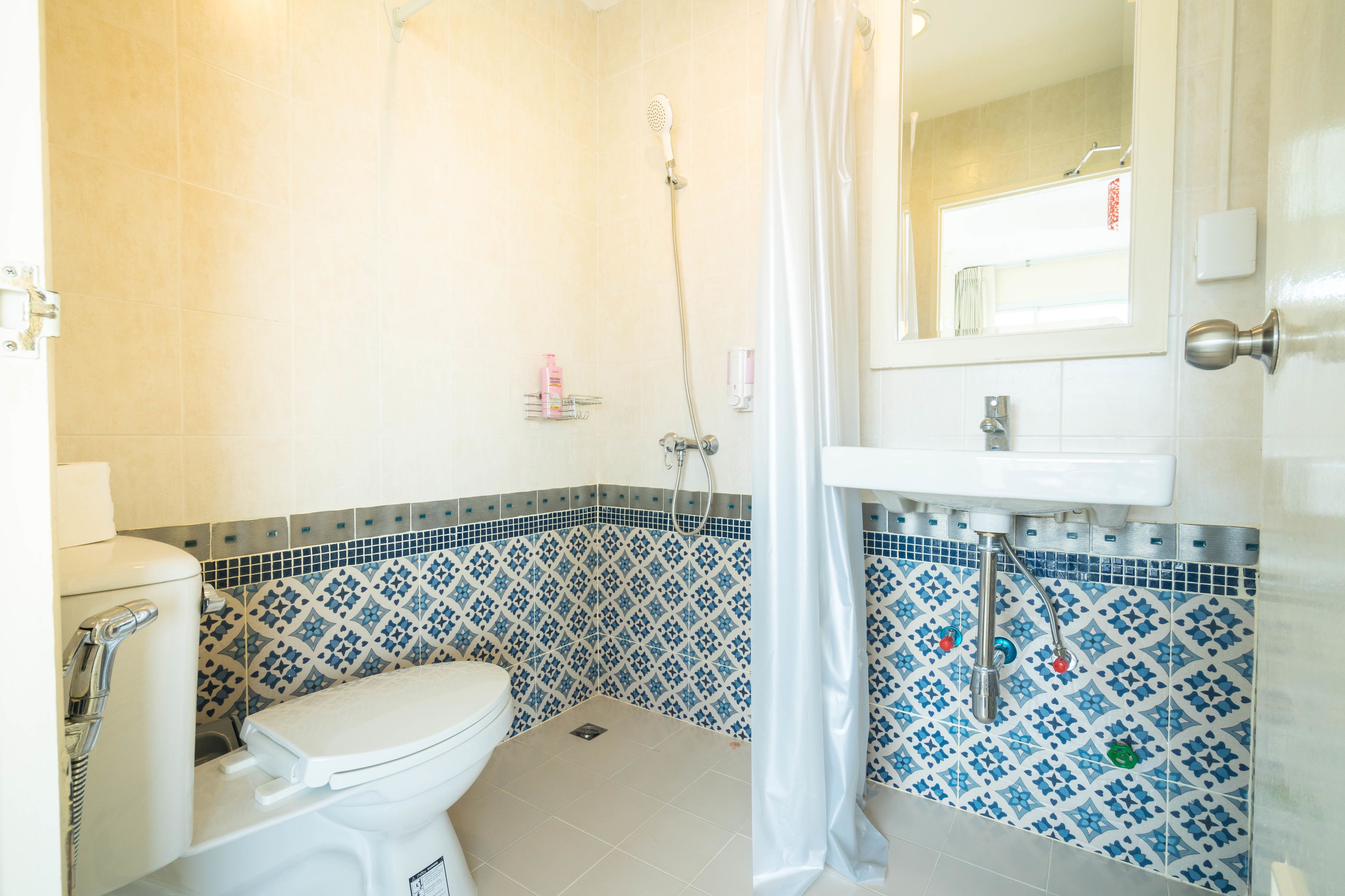 Een badkamer met toilet, douche en wastafel.