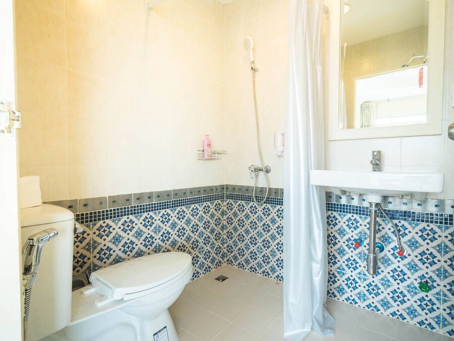 Een badkamer met toilet, douche en wastafel.