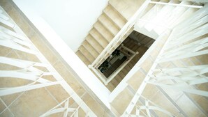 A spiral staircase with beige steps and white railings, leading to an upper floor. - Baan Anodat (Nonthaburi)