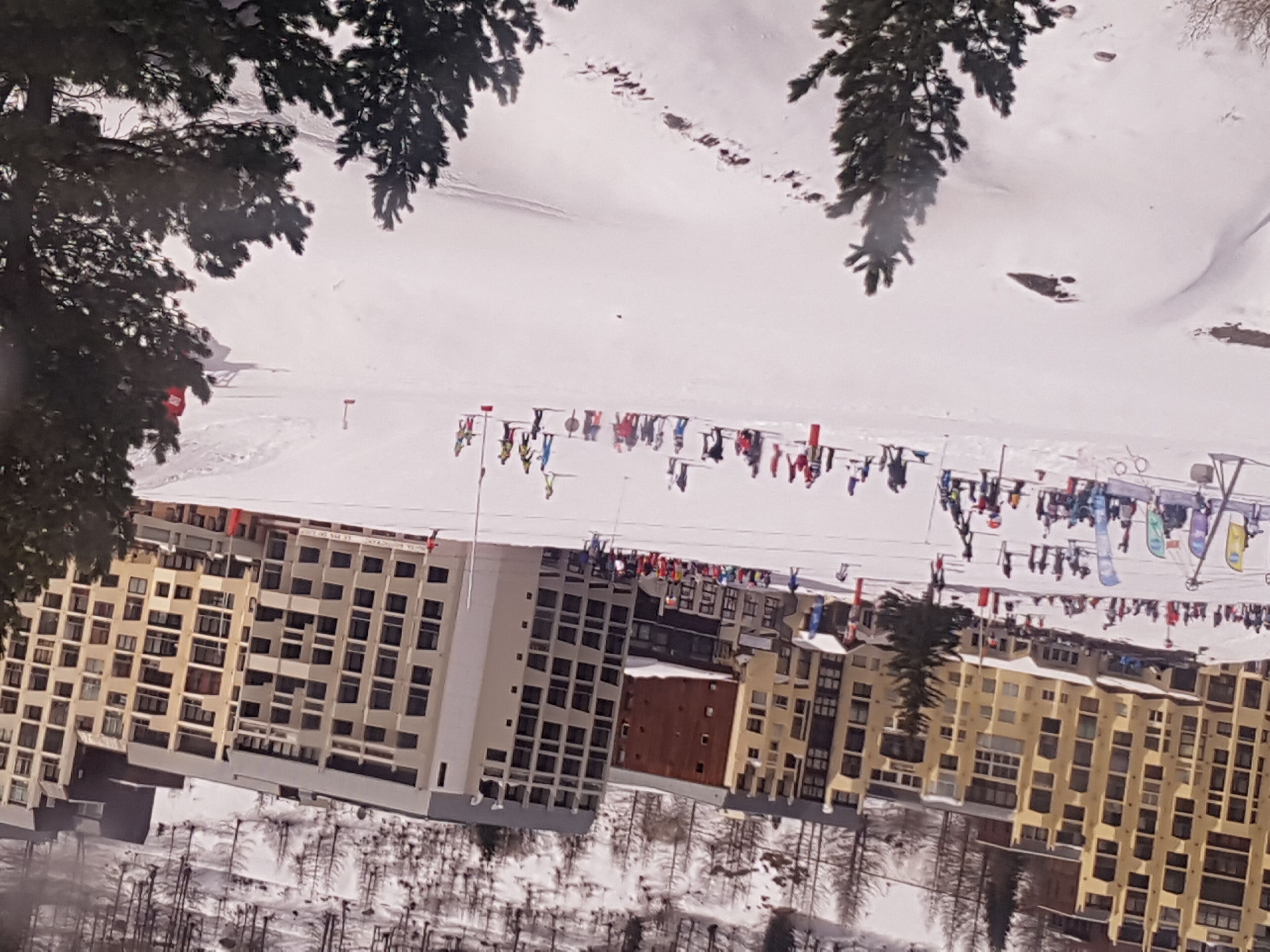 Une piste de ski enneigée, avec des bâtiments en arrière-plan.