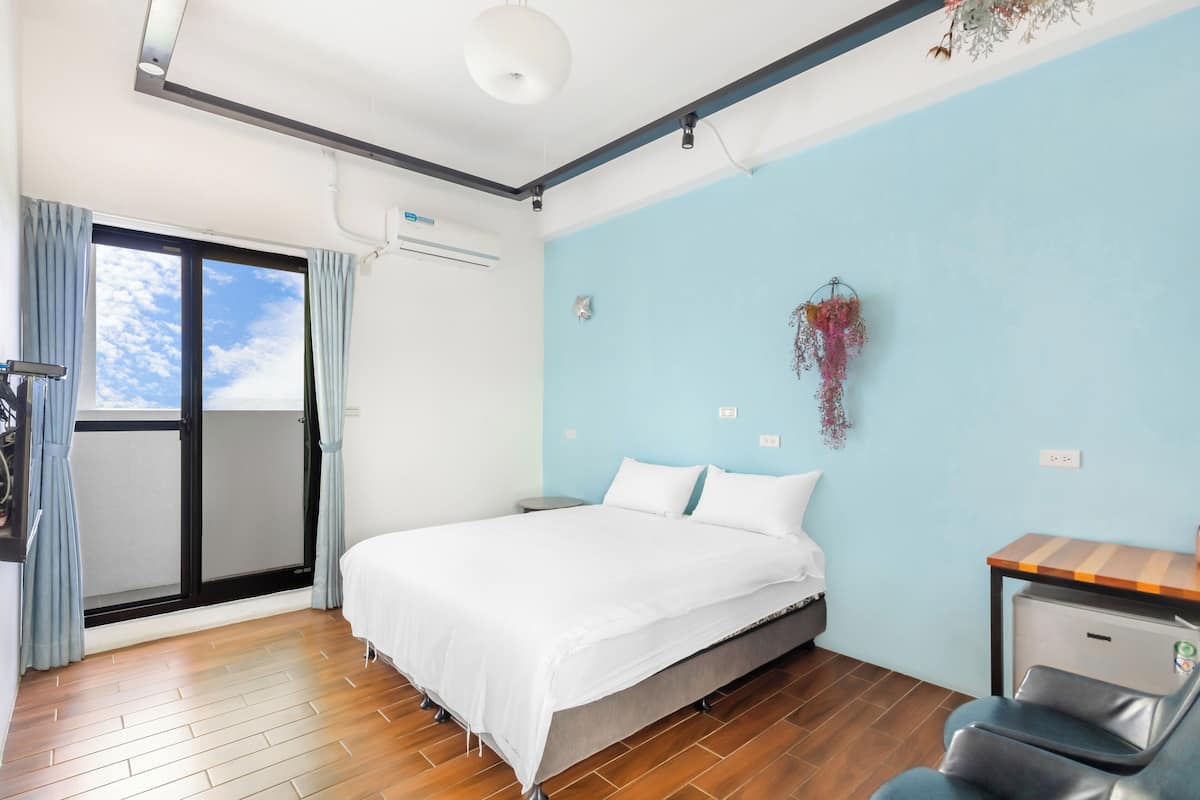 Un dormitorio con una cama, un escritorio y una silla.