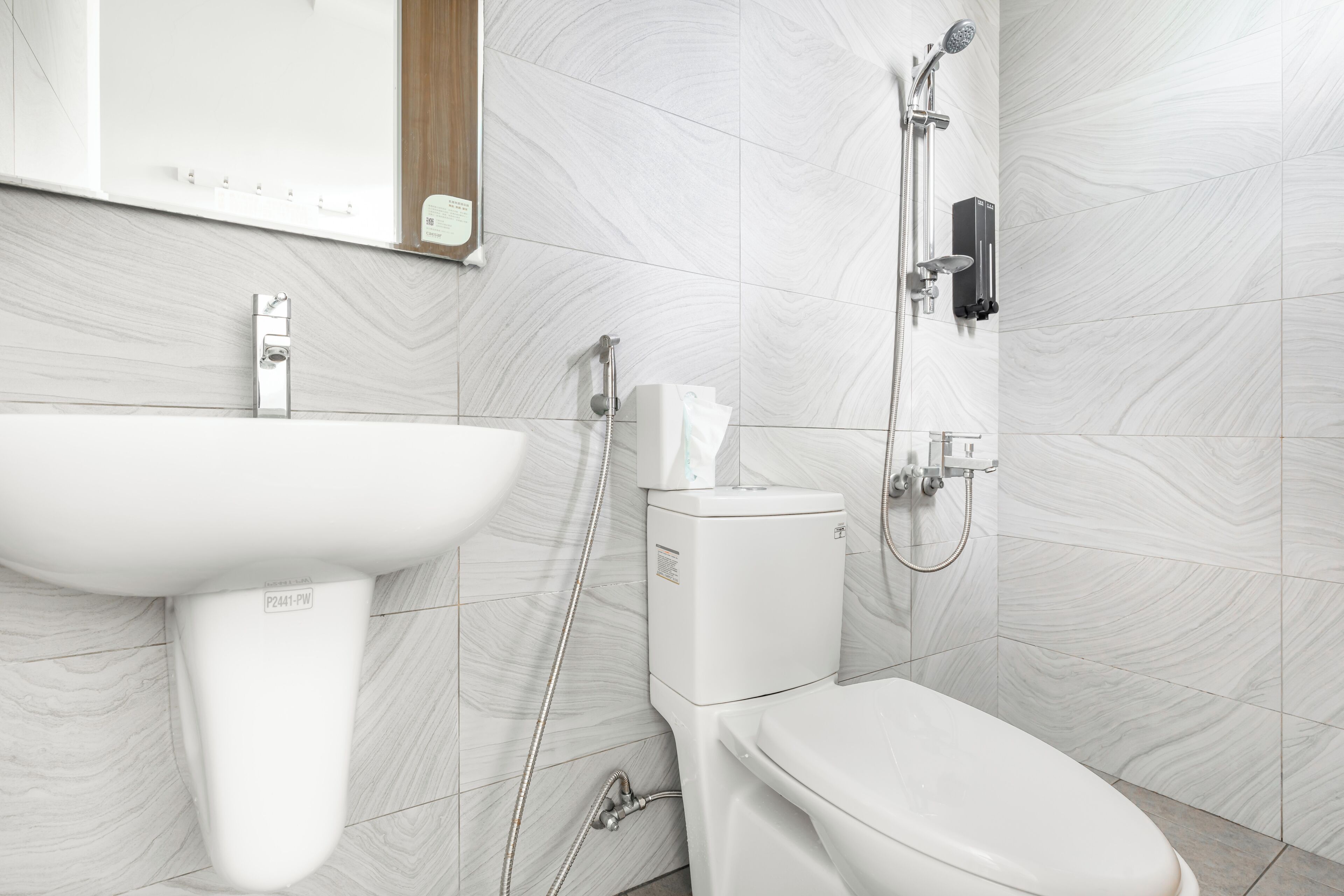 A modern bathroom with a white sink, toilet, and shower.