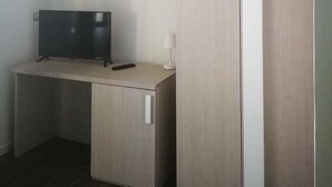 A small, modern room with a desk, a television, and a wardrobe. - Borgo Marinaro (Cetraro)