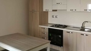 A modern kitchen with light wood cabinets, a stainless steel sink, and a black dishwasher. - Borgo Marinaro (Cetraro)