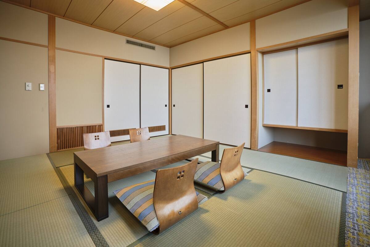 A traditional Japanese room with tatami flooring, a low wooden table, and sliding shoji doors.