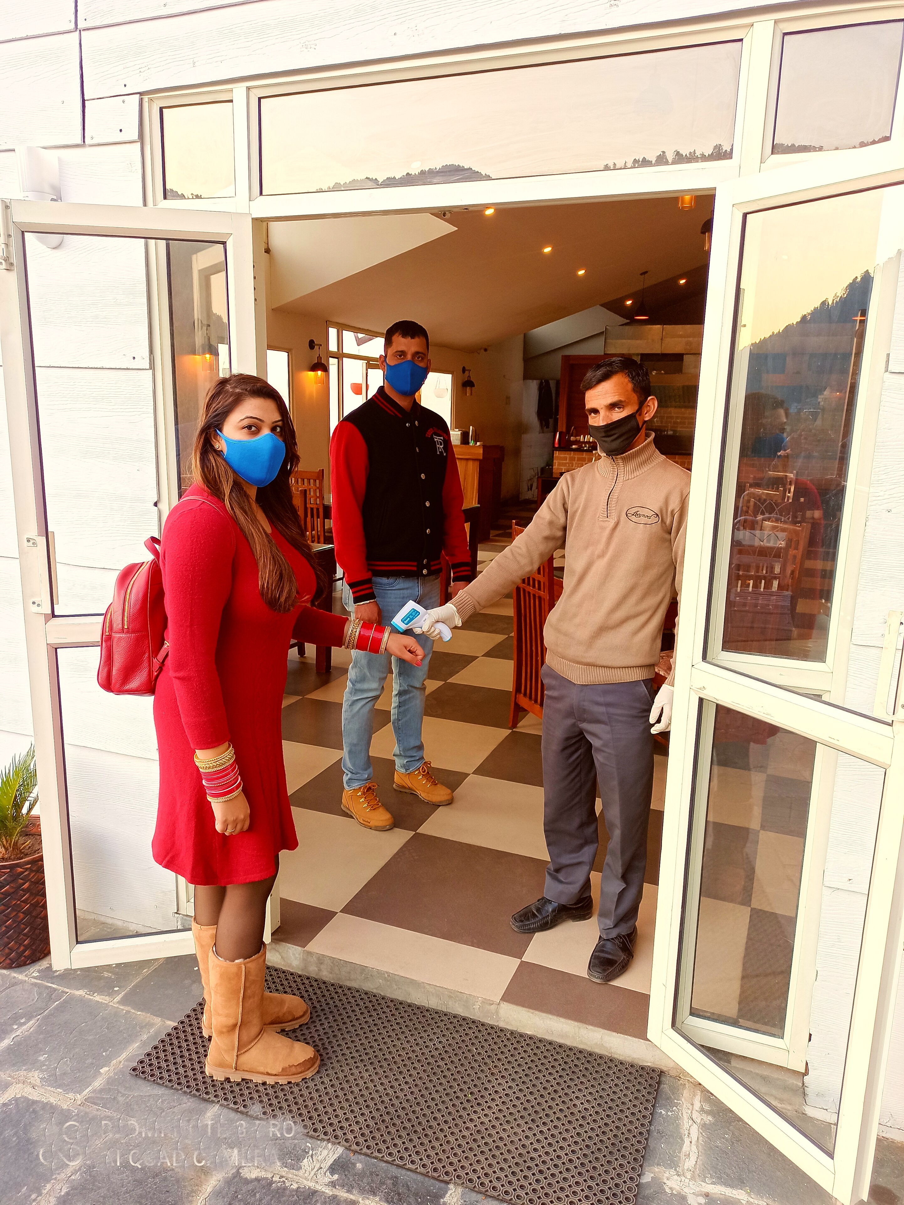 Entrada de un hotel con mostrador de recepción, zona de atención al cliente y vista al exterior.