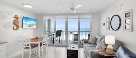 Una sala de estar moderna con balcón, comedor y vista al mar.