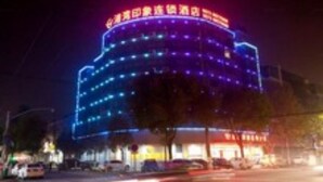 A multi-story building with illuminated signage at the top. - Gang Wan Yin Xiang Hotel (Jiaxing)