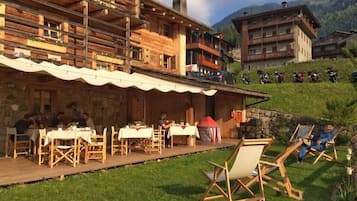 Un chalet de madera con mobiliario exterior y zona de comedor.