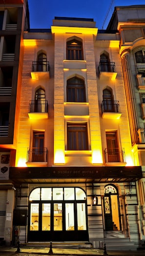 La façade d’un hôtel, ornée de nombreux balcons, de grandes fenêtres et d’une entrée imposante.