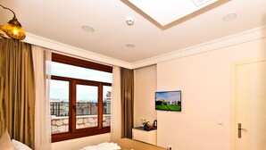 A hotel room with a bed, a window with curtains, a red rug, and a painting on the wall. - Nusret Bey Hotel (Istanbul)