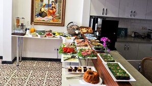 A buffet setup with various food items, a decorative painting, and a patterned floor. - Nusret Bey Hotel (Istanbul)