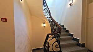A staircase with ornate black metal railings, a handrail, and a patterned carpet. - Nusret Bey Hotel (Istanbul)