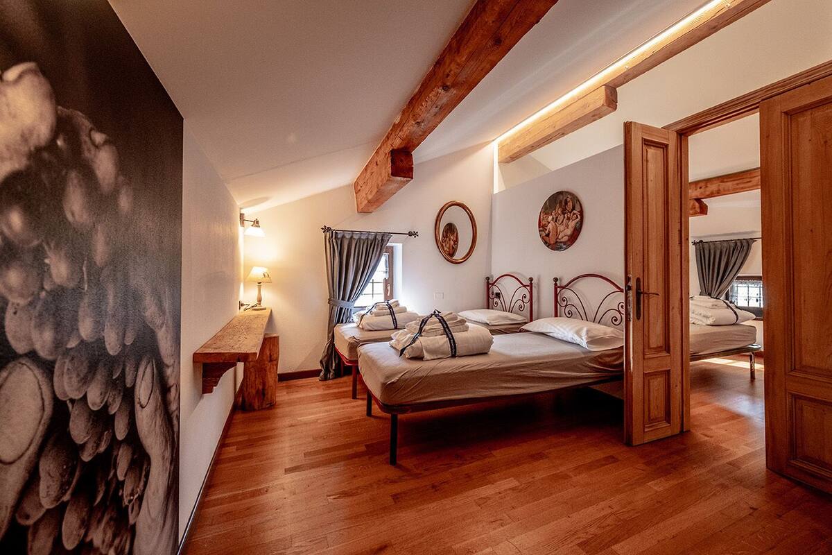 Un dormitorio acogedor con techo de madera, una cama con cabecera, una mesita de noche y una lámpara.