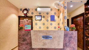 Un mostrador de recepción con un cartel que dice 'RECEPTION', un reloj y un certificado enmarcado en la pared.