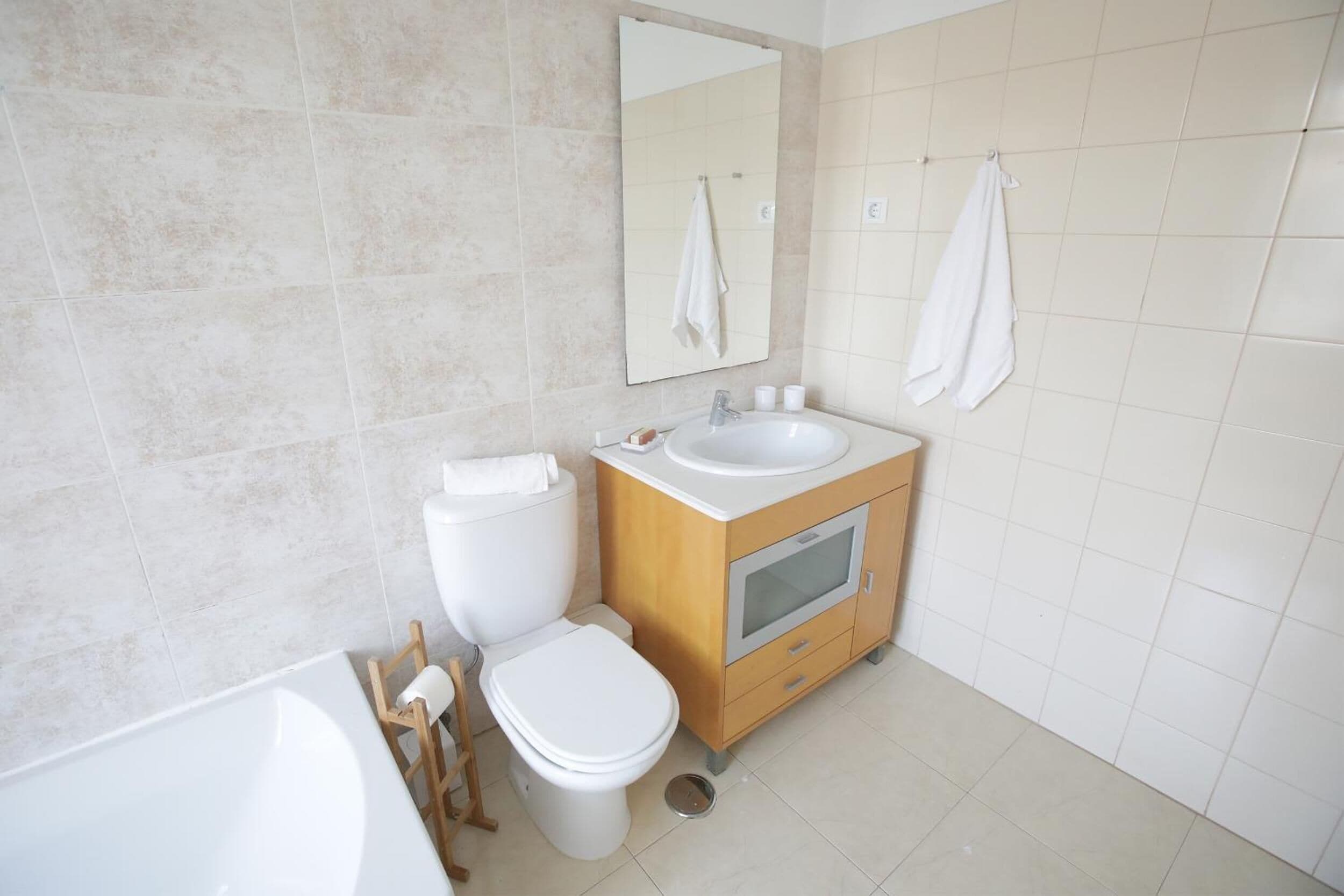 A modern bathroom with a toilet, sink, and mirror.