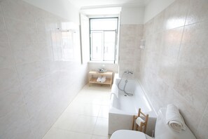 Habitación triple, balcón | Baño | Bañera, zapatillas y toallas