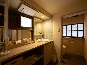 Une salle de bain avec un meuble-lavabo en bois, un évier, un miroir et une fenêtre.