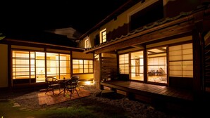 A traditional Japanese-style building with tatami mat flooring, a wooden deck, and sliding doors with paper windows. - UCHIKO-Inn HISA (Uchiko)
