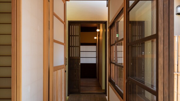 A narrow hallway with traditional wooden sliding doors and a wooden floor. - UCHIKO-Inn HISA (Uchiko)