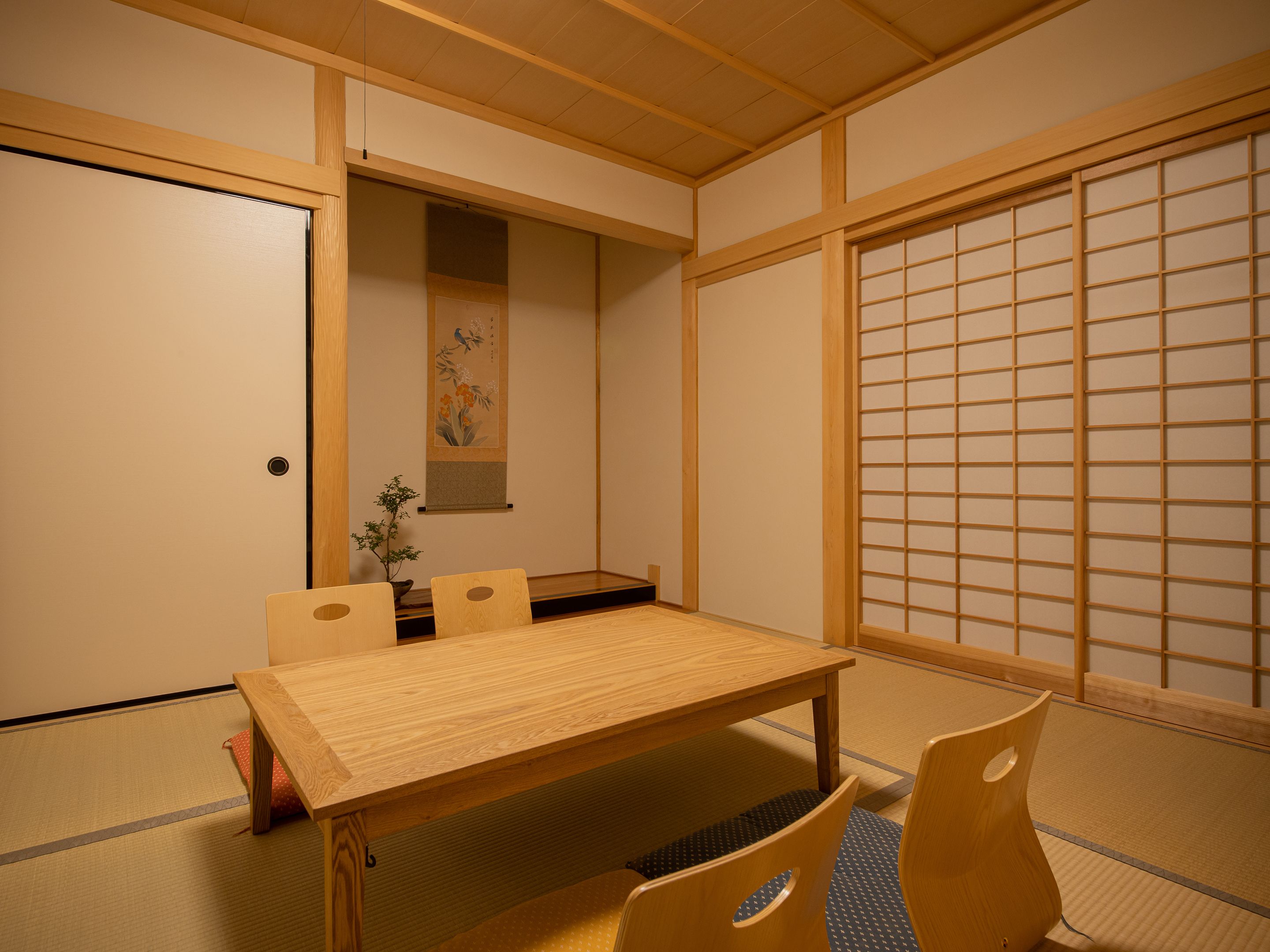 A traditional Japanese room with tatami flooring, a low wooden table, and a shoji screen.