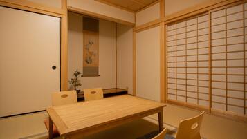A traditional Japanese room with tatami flooring, a low wooden table, and a shoji screen.