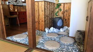 Een traditioneel Japans interieur met tatami vloerbedekking, een shoji scherm en een houten hek.