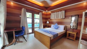 A bedroom with a wooden bed, a desk, and a chair. - Ferellee Beachfront Inn (San Vicente)
