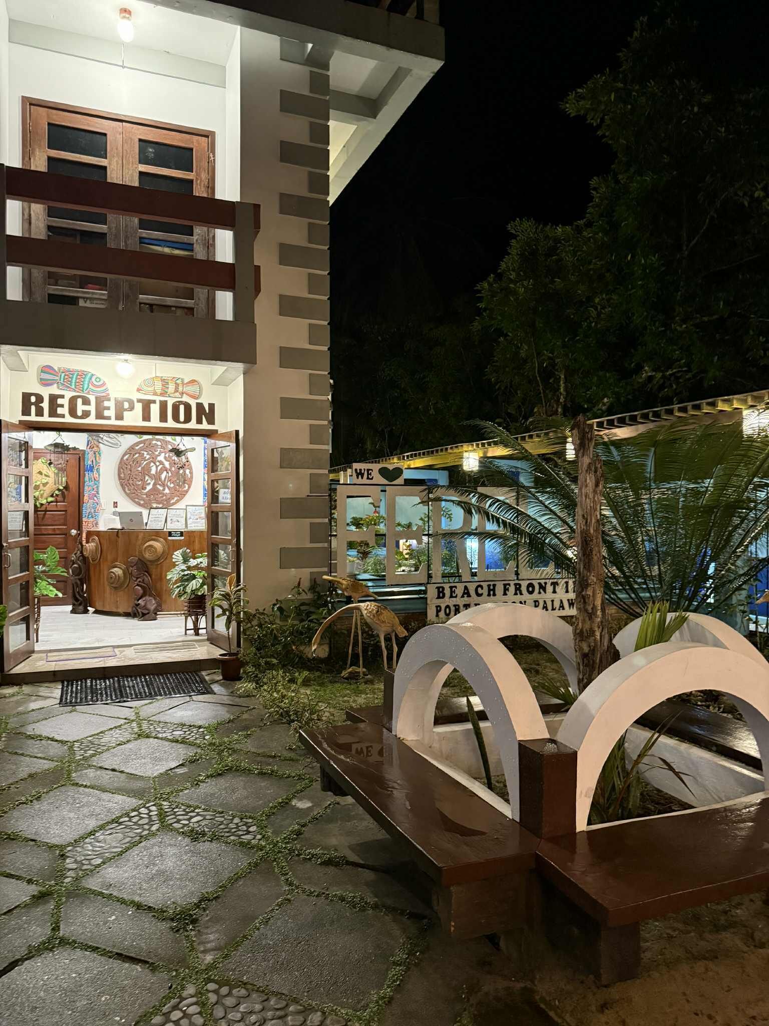 A reception area with a sign, a bench, and a decorative archway.